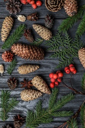 Flat lay composition with pinecones on black wooden background
