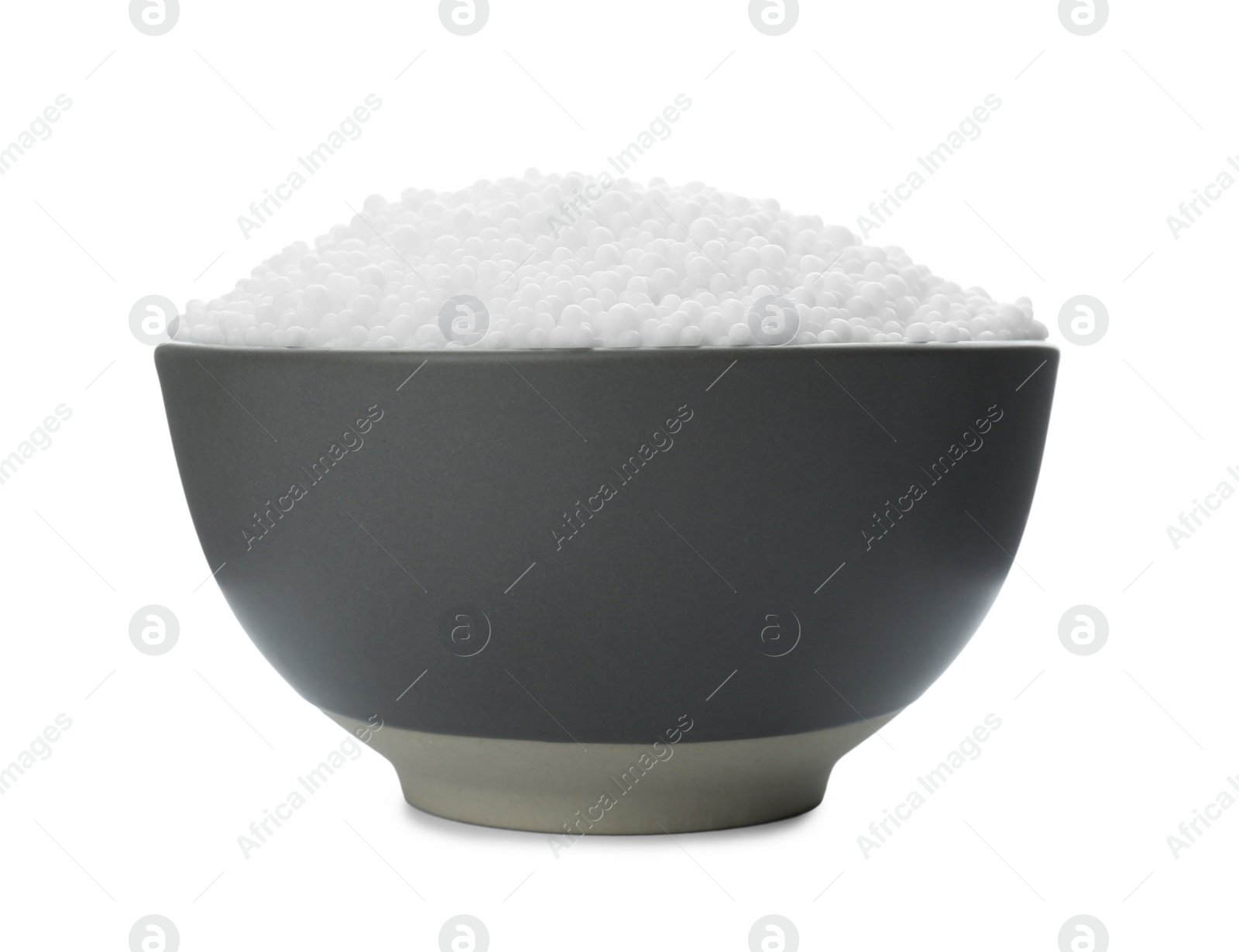 Photo of Pellets of ammonium nitrate in bowl isolated on white. Mineral fertilizer