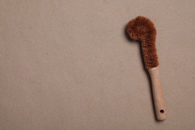 Photo of Cleaning brush on pale brown background, top view. Space for text