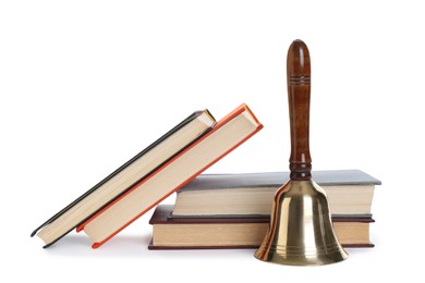 Photo of Golden school bell with wooden handle and books on white background