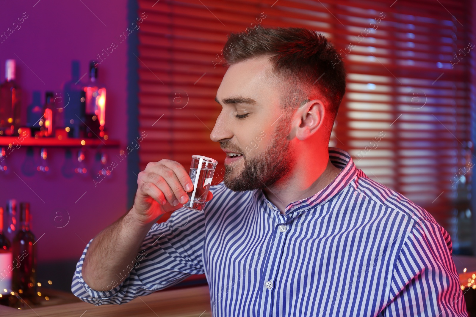 Photo of Young man with Mexican Tequila shot in bar