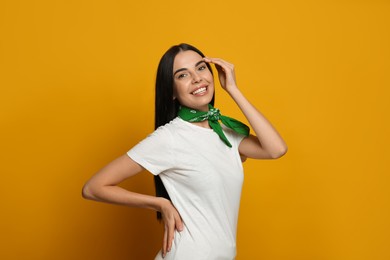 Photo of Young woman wearing stylish bandana on orange background