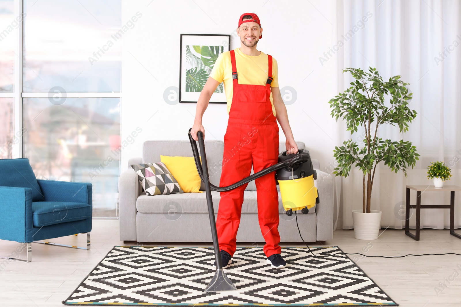 Photo of Mature man hoovering carpet with vacuum cleaner in living room