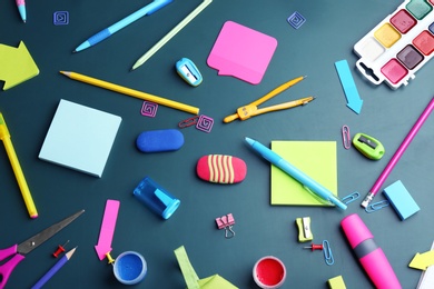 Photo of Different bright school stationery on green background, flat lay