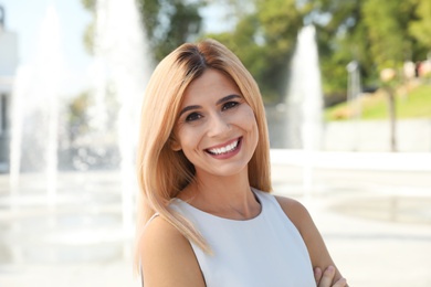 Portrait of beautiful blonde woman outdoors on sunny day