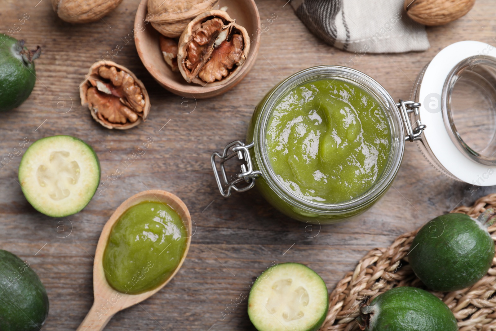 Photo of Feijoa jam and fruits on wooden table, flat lay