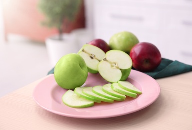 Photo of Plate with ripe apples on kitchen table