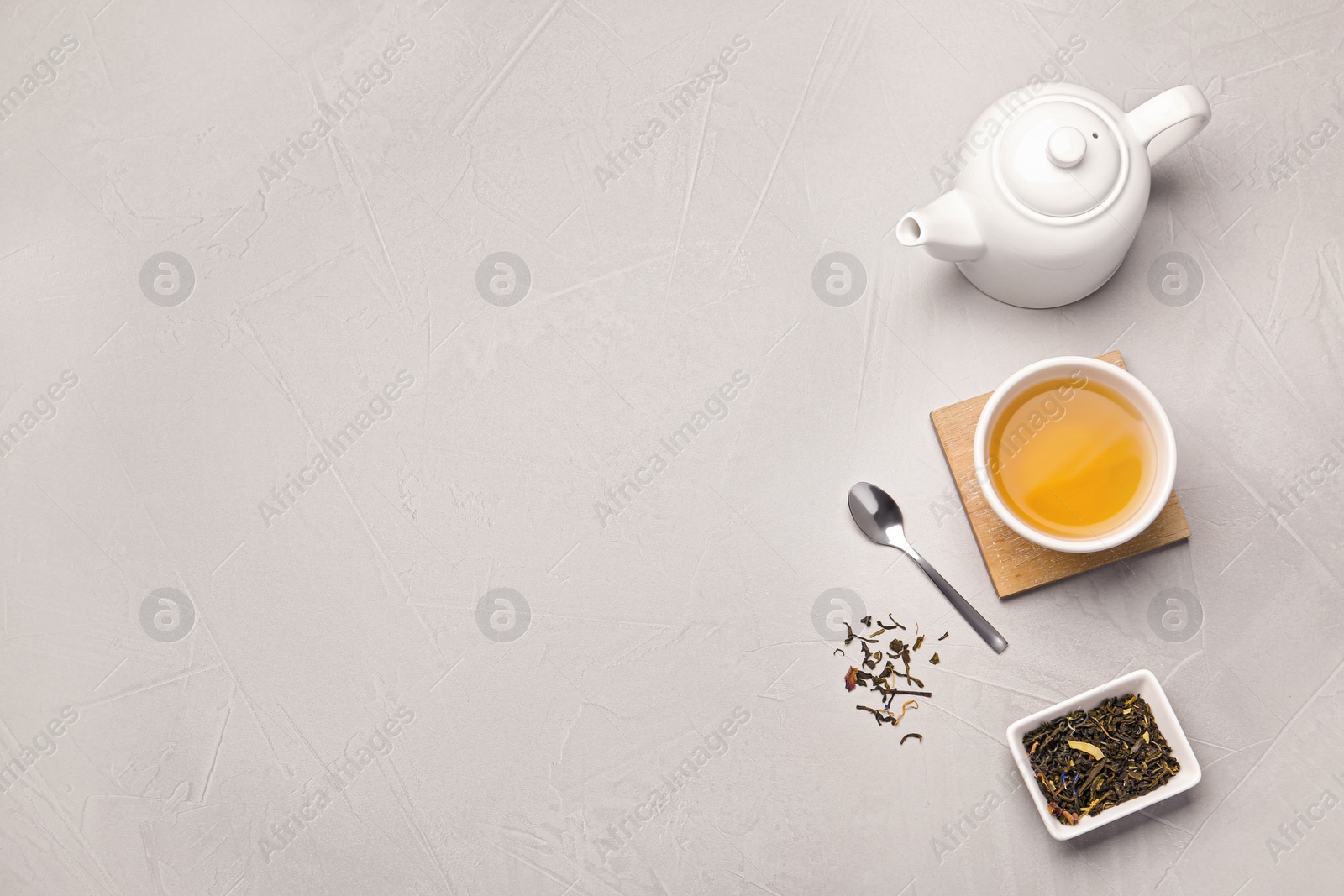 Photo of Flat lay composition with cup of hot aromatic tea on light grey table. Space for text