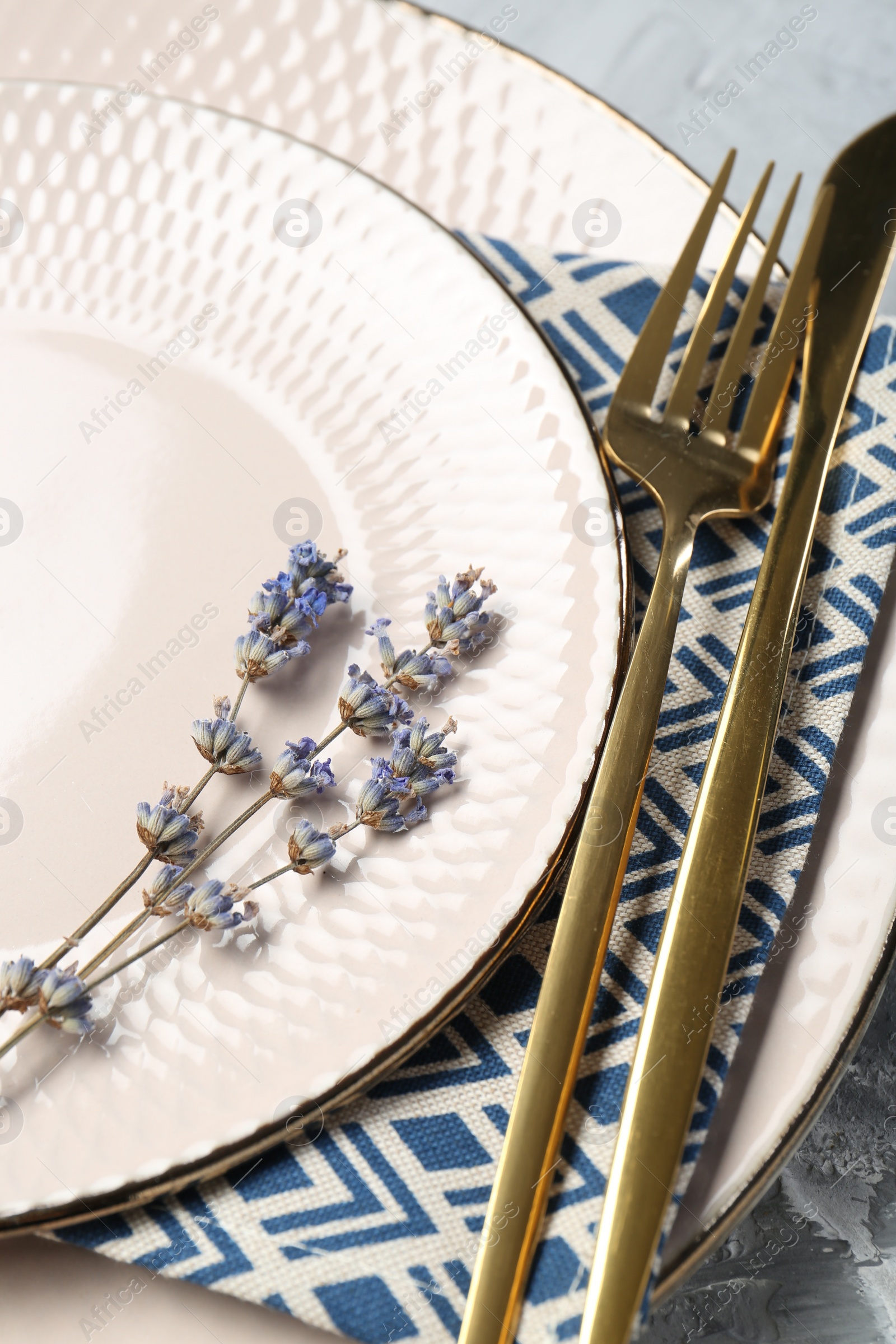 Photo of Clean plates, cutlery, napkin and lavender flowers on table, closeup