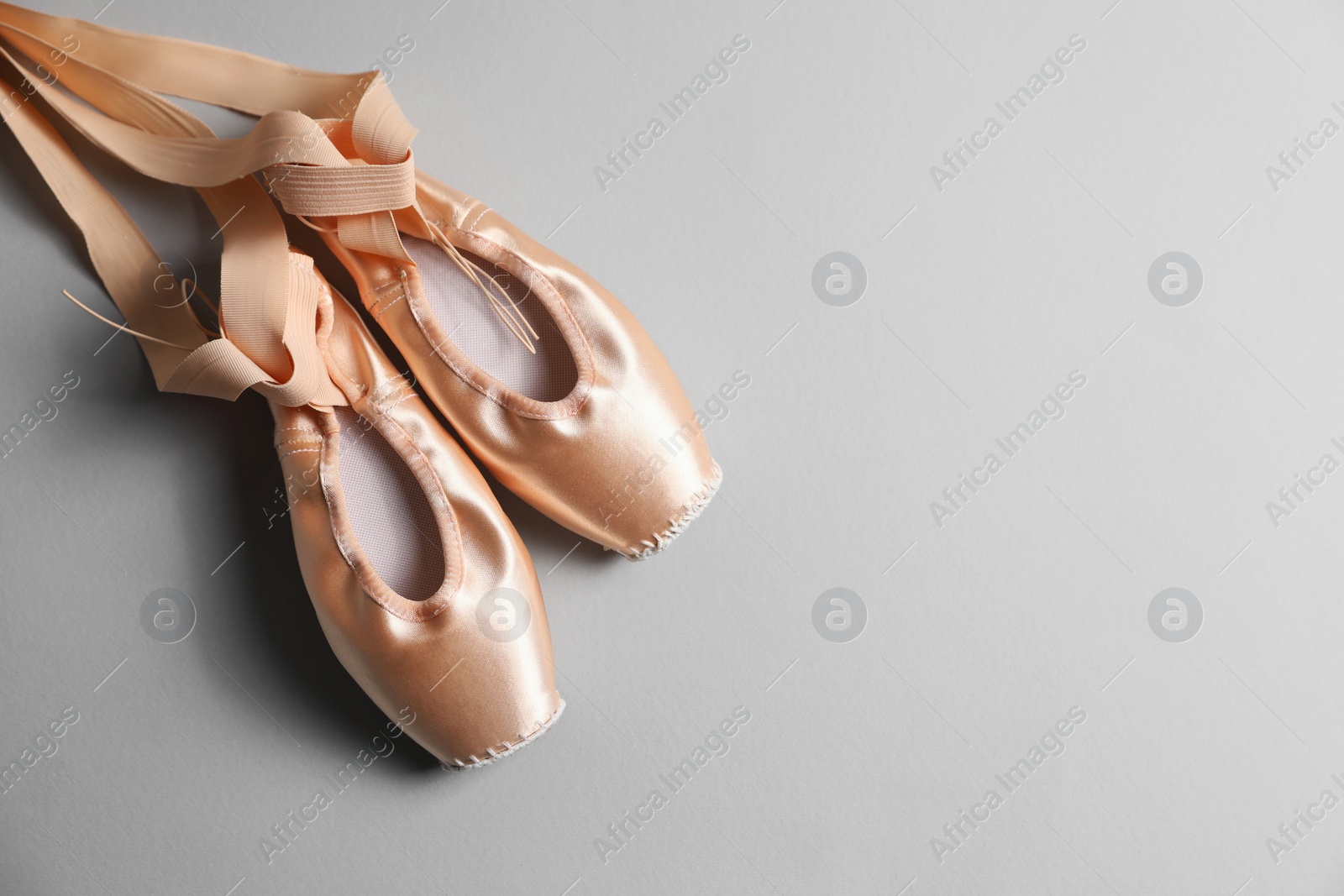 Photo of Ballet shoes. Elegant pointes on grey background, flat lay. Space for text