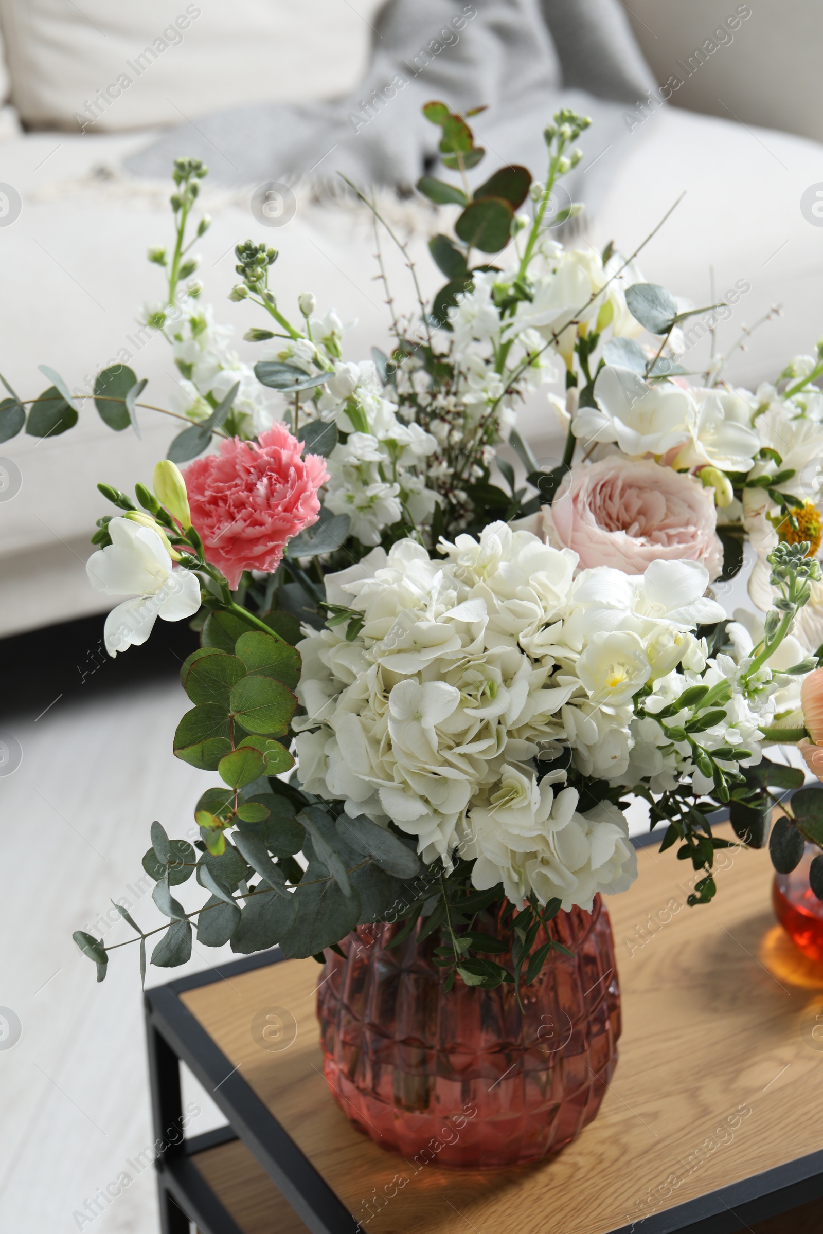 Photo of Bouquet of beautiful flowers on wooden table indoors