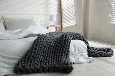 Photo of Soft chunky knit blanket on bed in room