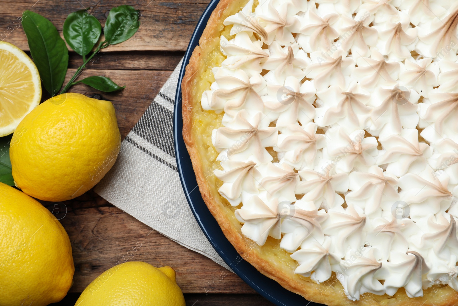 Photo of Flat lay composition with delicious lemon meringue pie on wooden table