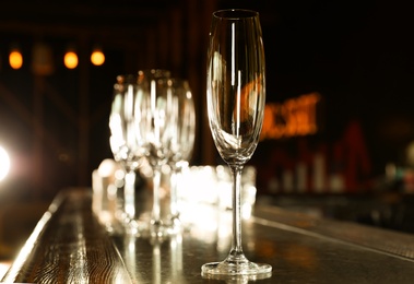 Photo of Empty clean champagne glass on counter in bar
