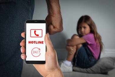 Image of Woman calling domestic violence hotline to prevent aggression upon little girl