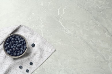 Photo of Ceramic bowl with blueberries on grey table, flat lay  and space for text. Cooking utensil