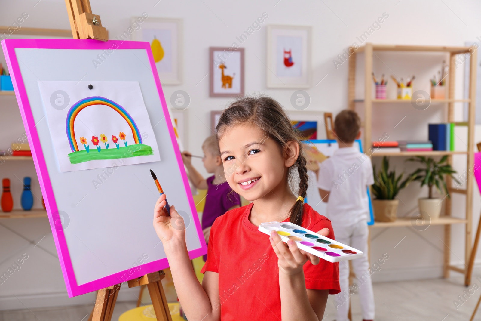 Photo of Cute little child painting during lesson in room