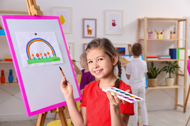 Cute little child painting during lesson in room