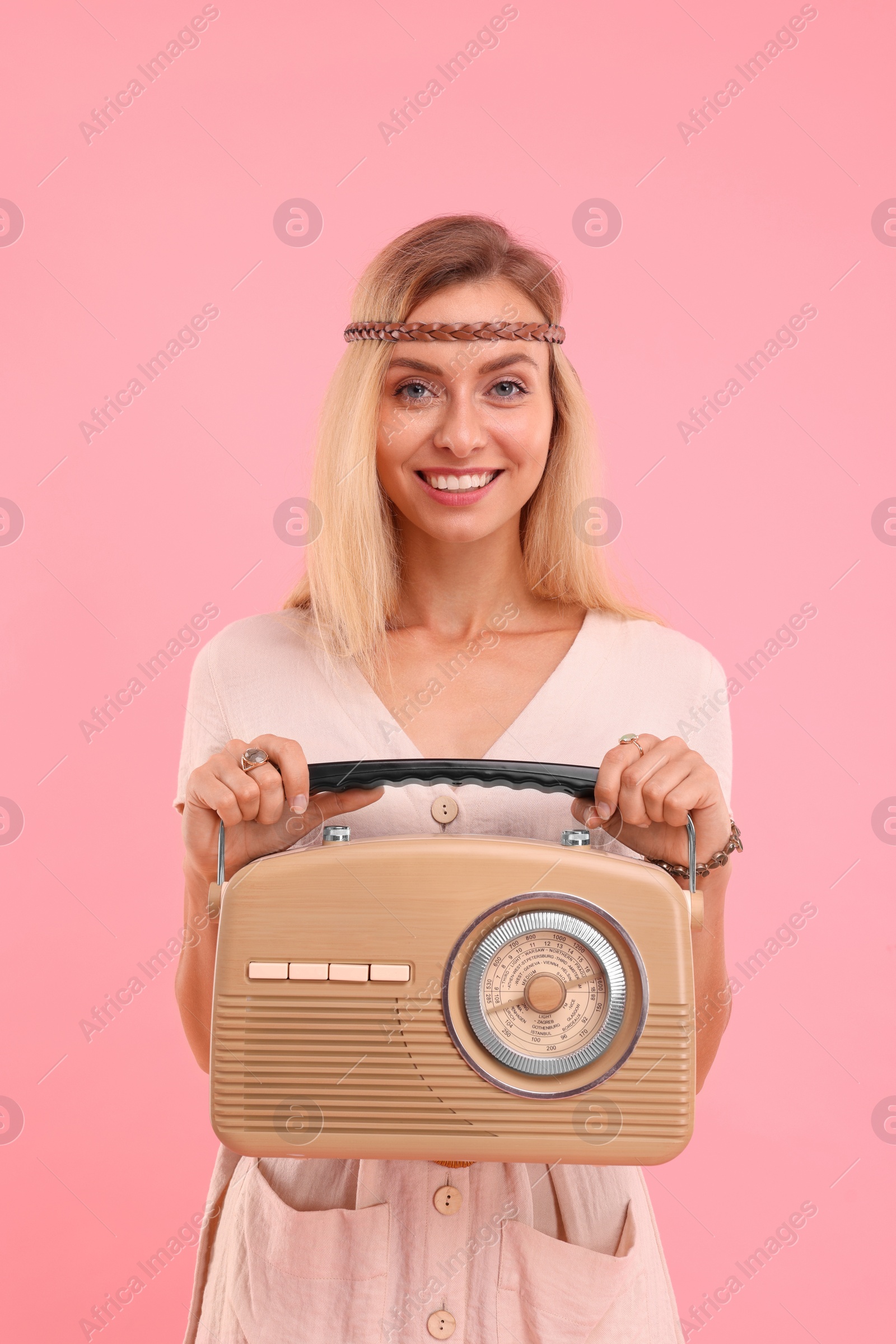 Photo of Portrait of happy hippie woman with retro radio receiver on pink background