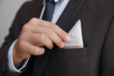 Photo of Man putting handkerchief into suit pocket, closeup view