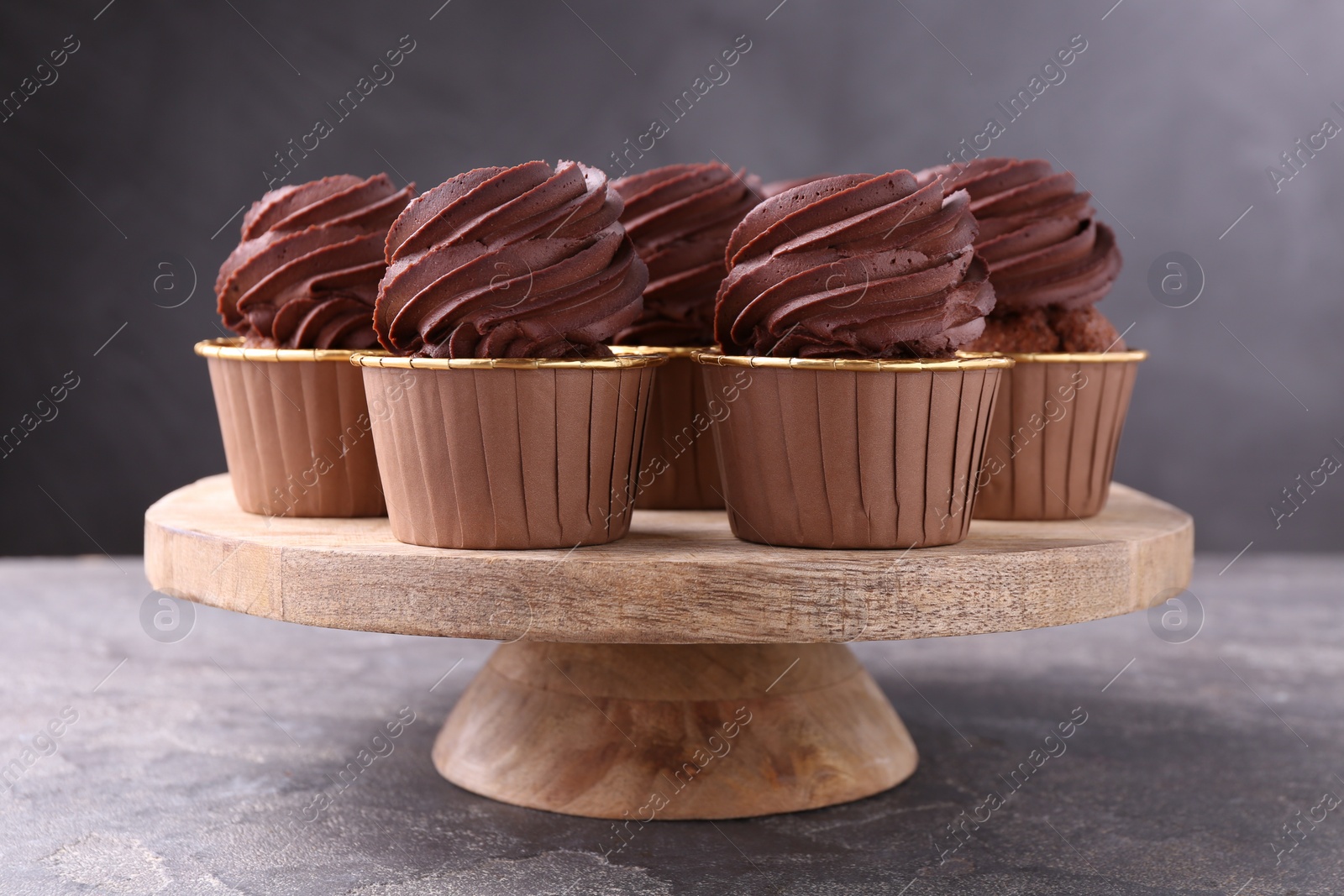 Photo of Delicious chocolate cupcakes on grey textured table