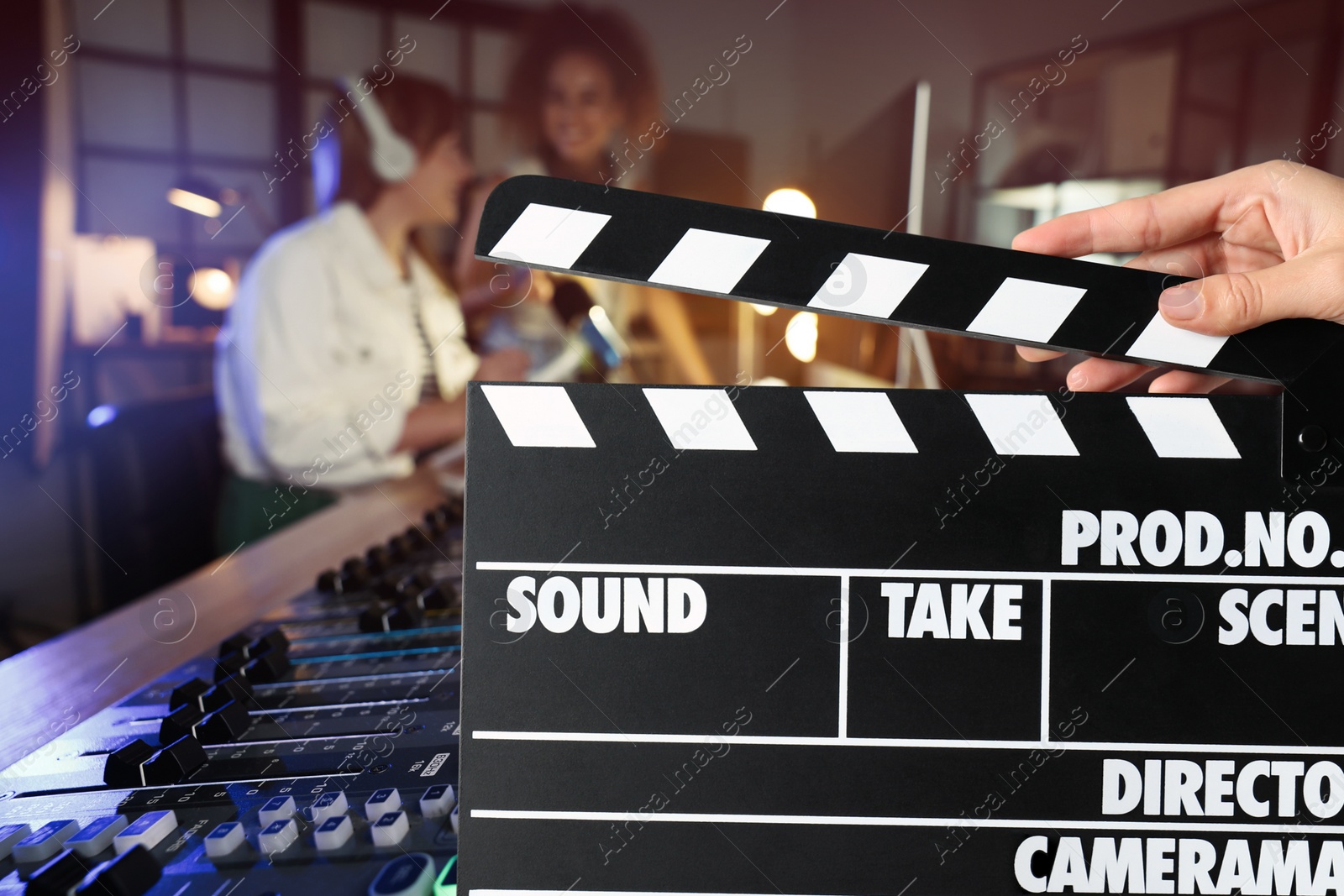 Image of Shooting movie. Second assistant camera holding clapperboard in front of radio studio workers (actors) at film set