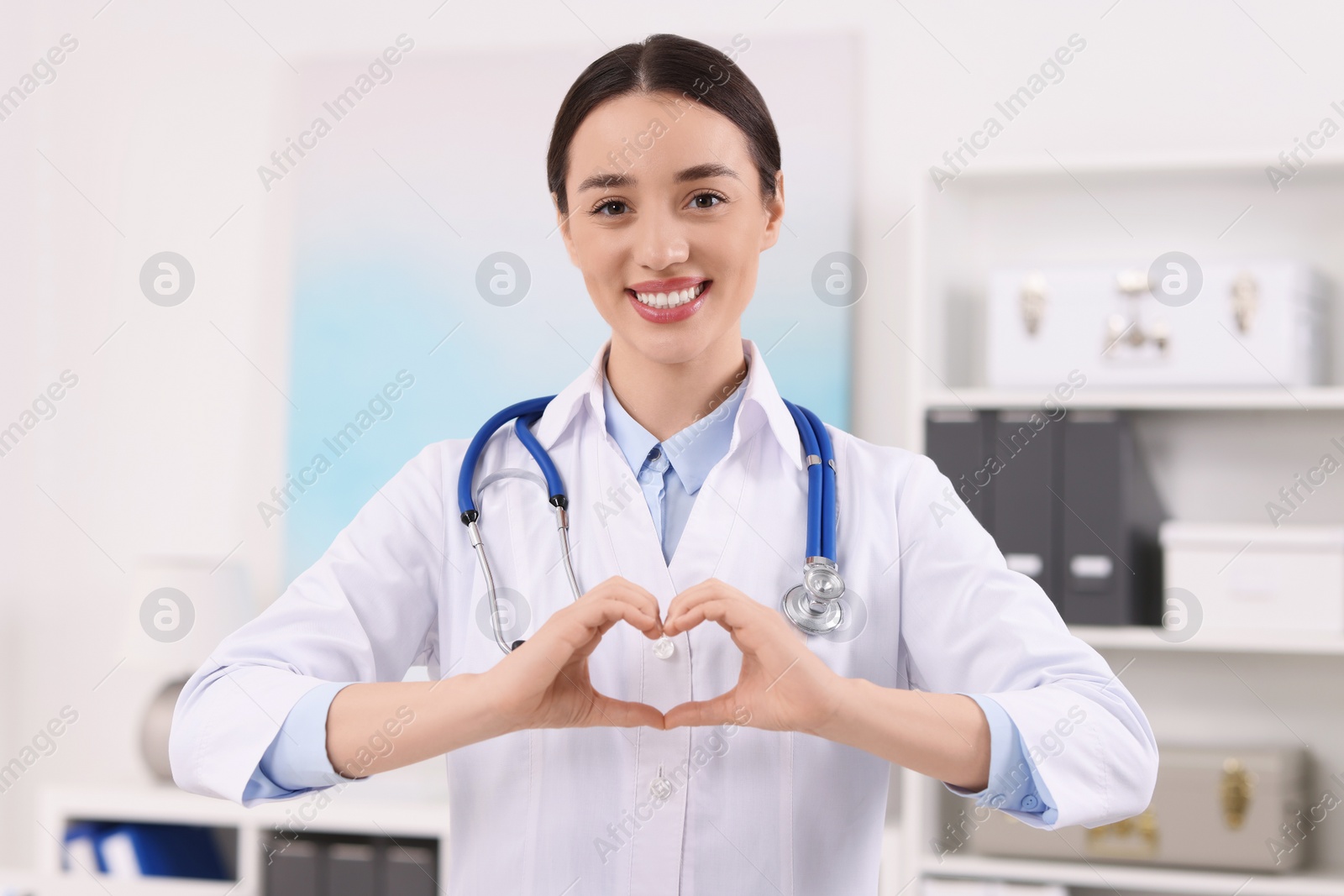 Photo of Doctor showing heart gesture with hands in clinic