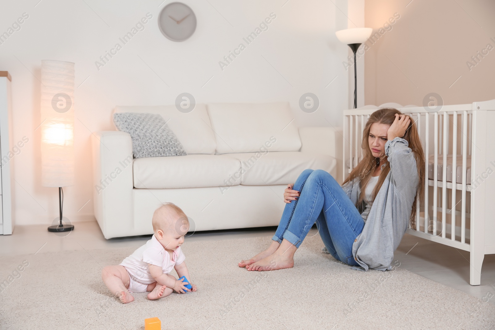 Photo of Young mother suffering from postnatal depression and cute baby girl at home