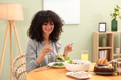 Photo of Woman having vegetarian meal at table in cafe