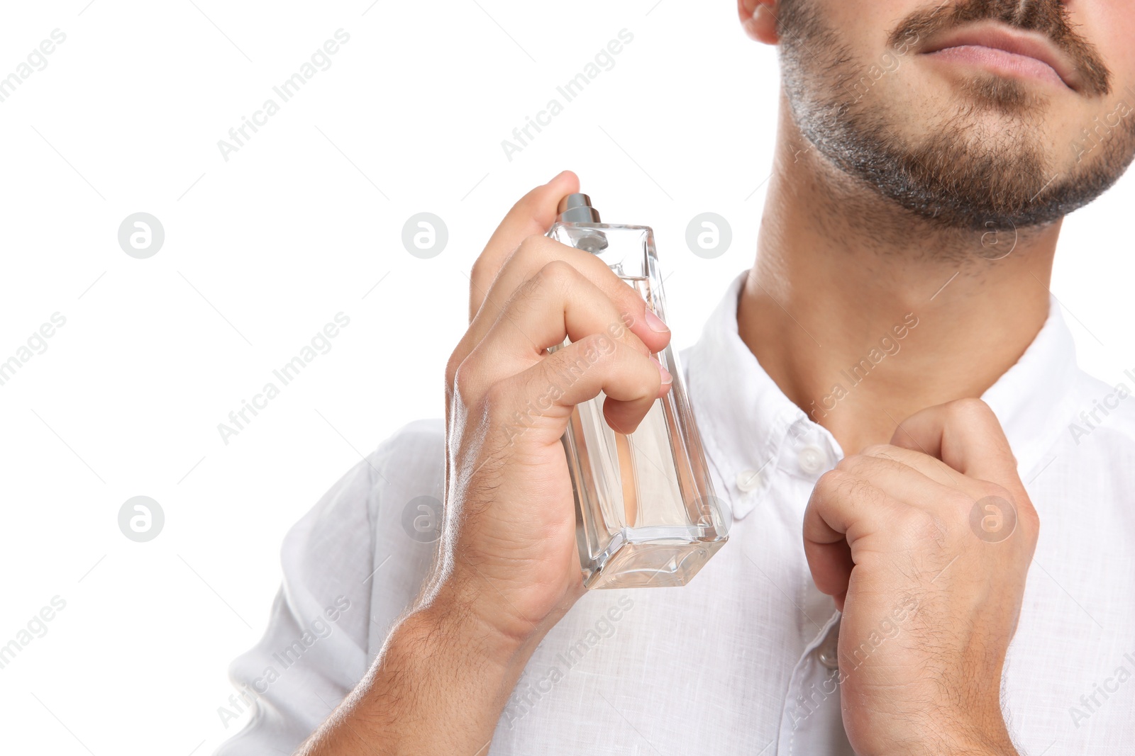 Photo of Young man applying perfume on white background, closeup