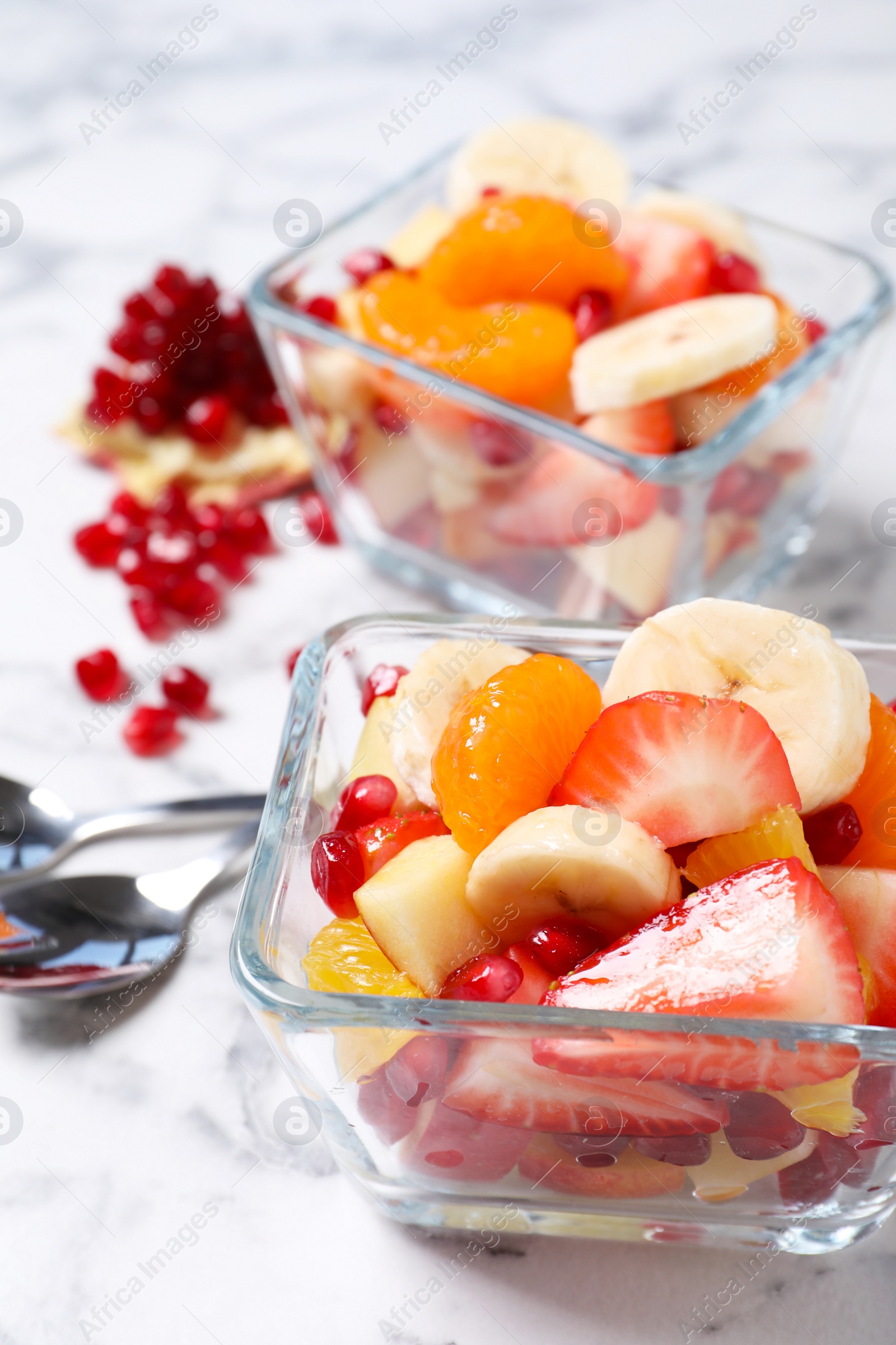 Photo of Delicious fresh fruit salad on white marble table