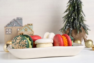 Beautifully decorated Christmas macarons and festive decor on white table