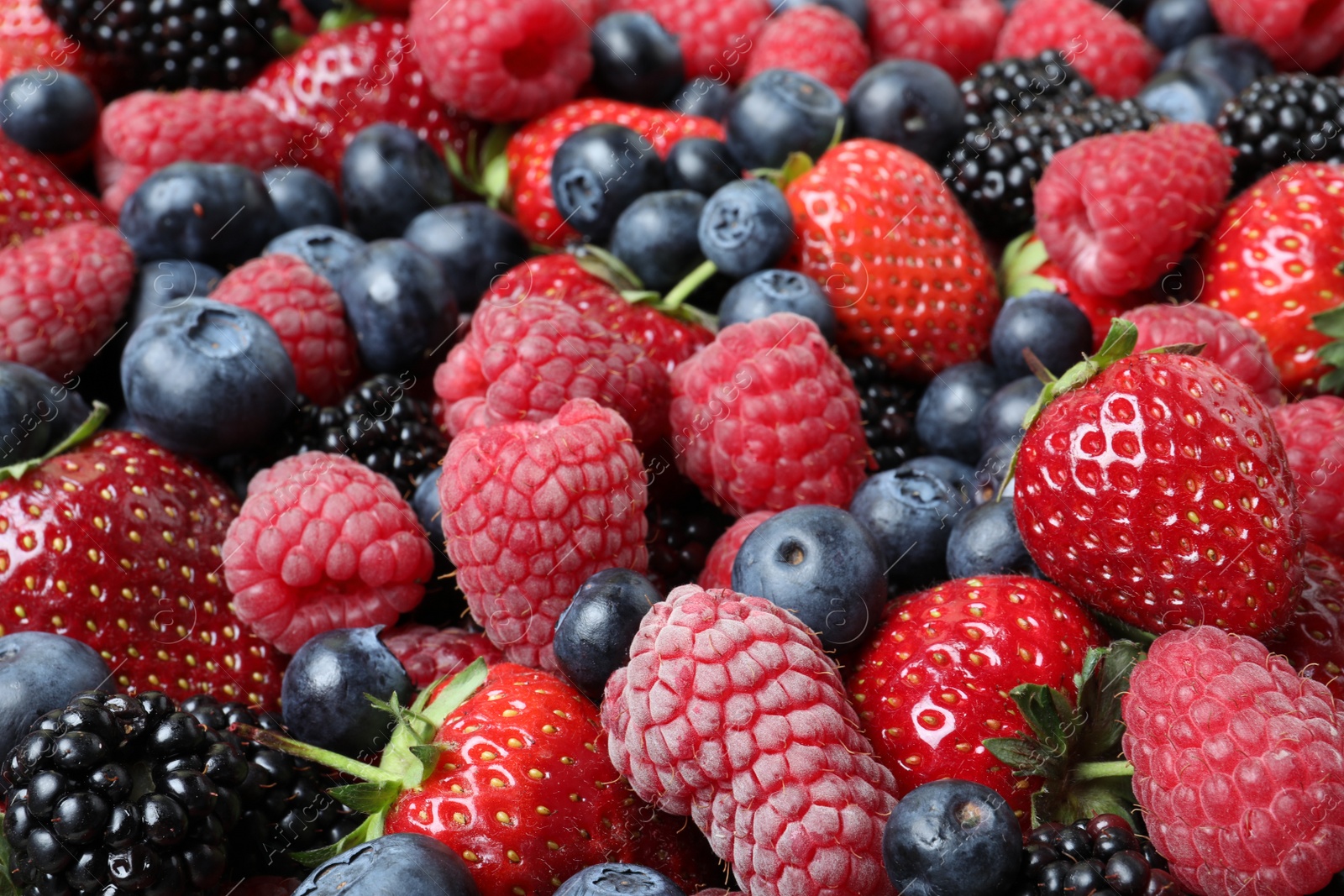 Photo of Mix of different ripe tasty berries as background, closeup view