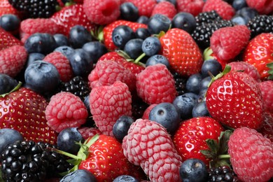 Photo of Mix of different ripe tasty berries as background, closeup view