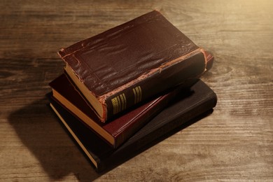 Stack of old hardcover books on wooden table