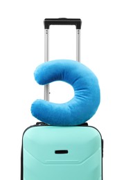 Photo of Soft travel pillow on turquoise suitcase isolated on white