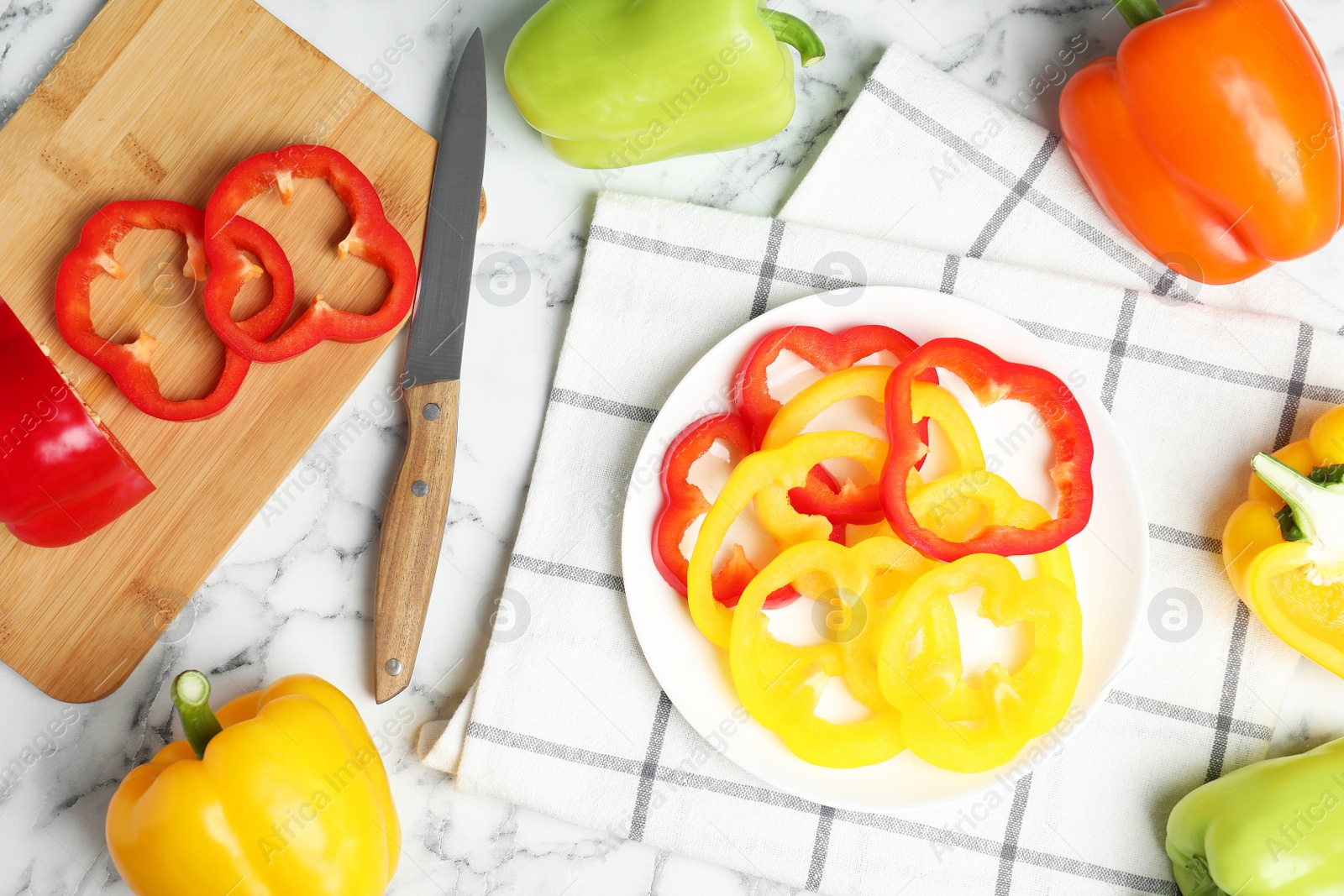 Photo of Flat lay composition with whole and cut ripe bell peppers on marble table