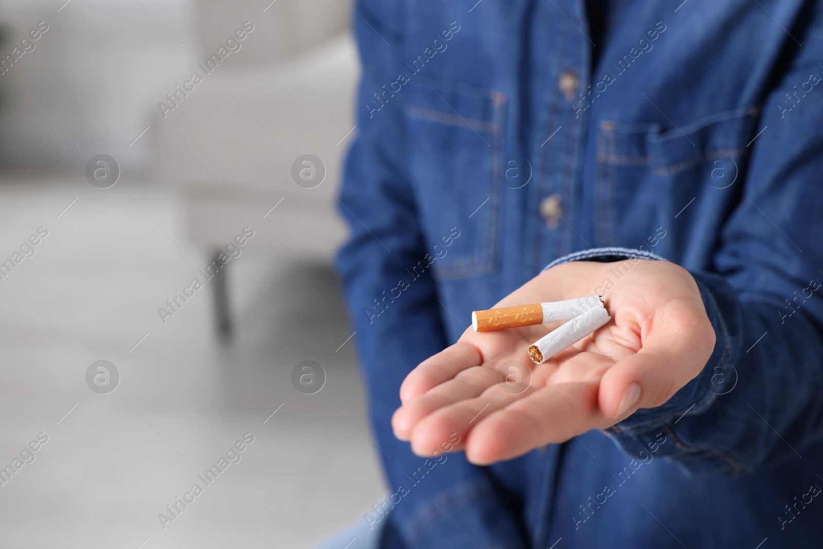 Photo of Quitting smoking concept. Woman holding broken cigarette on blurred background, closeup. Space for text