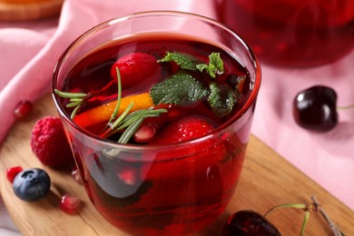 Photo of Glass of delicious refreshing sangria on board, closeup