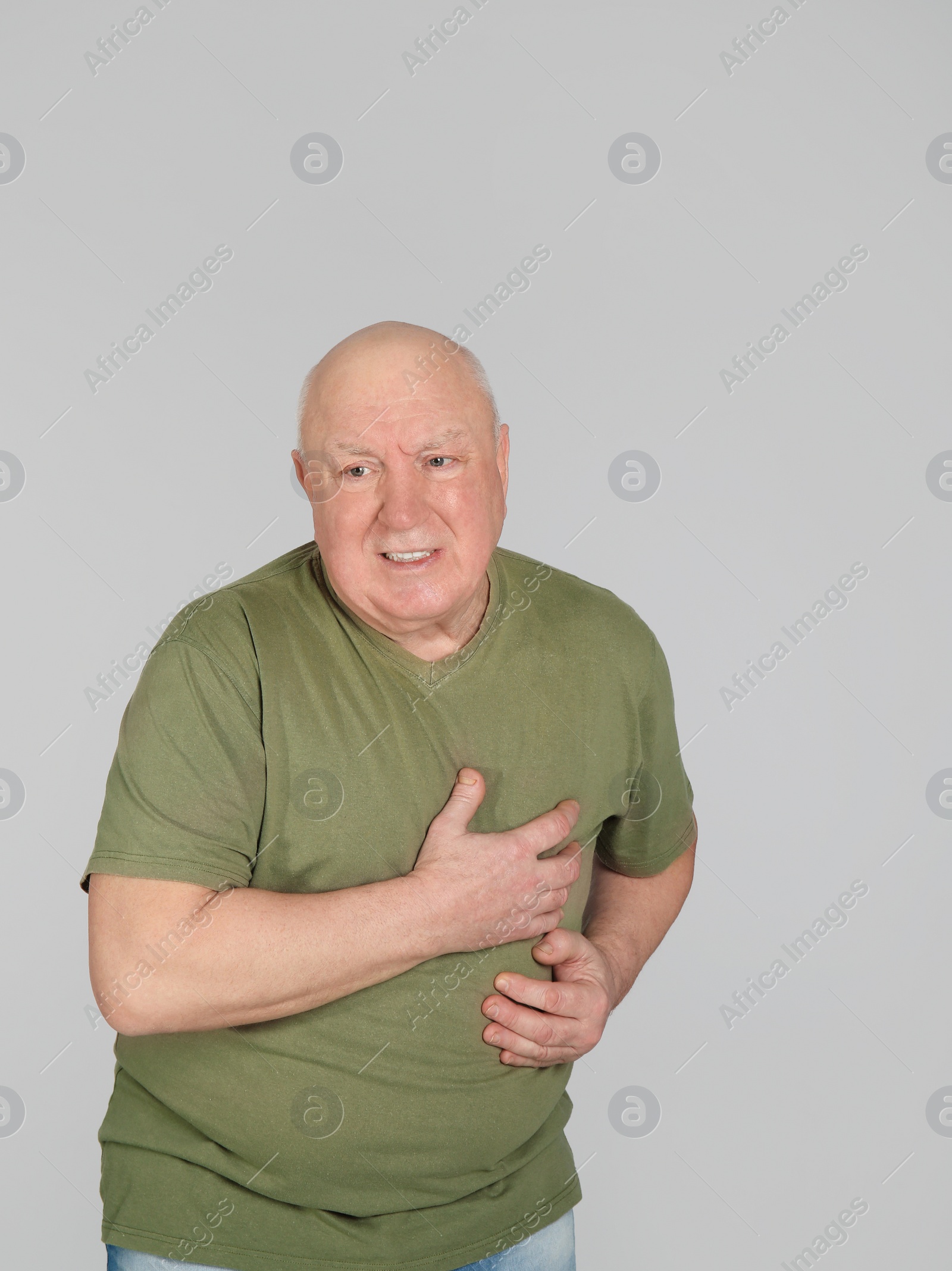 Photo of Senior man suffering from pain in chest on light background