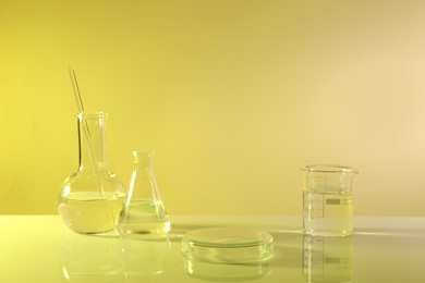 Laboratory analysis. Different glassware on table against yellow background
