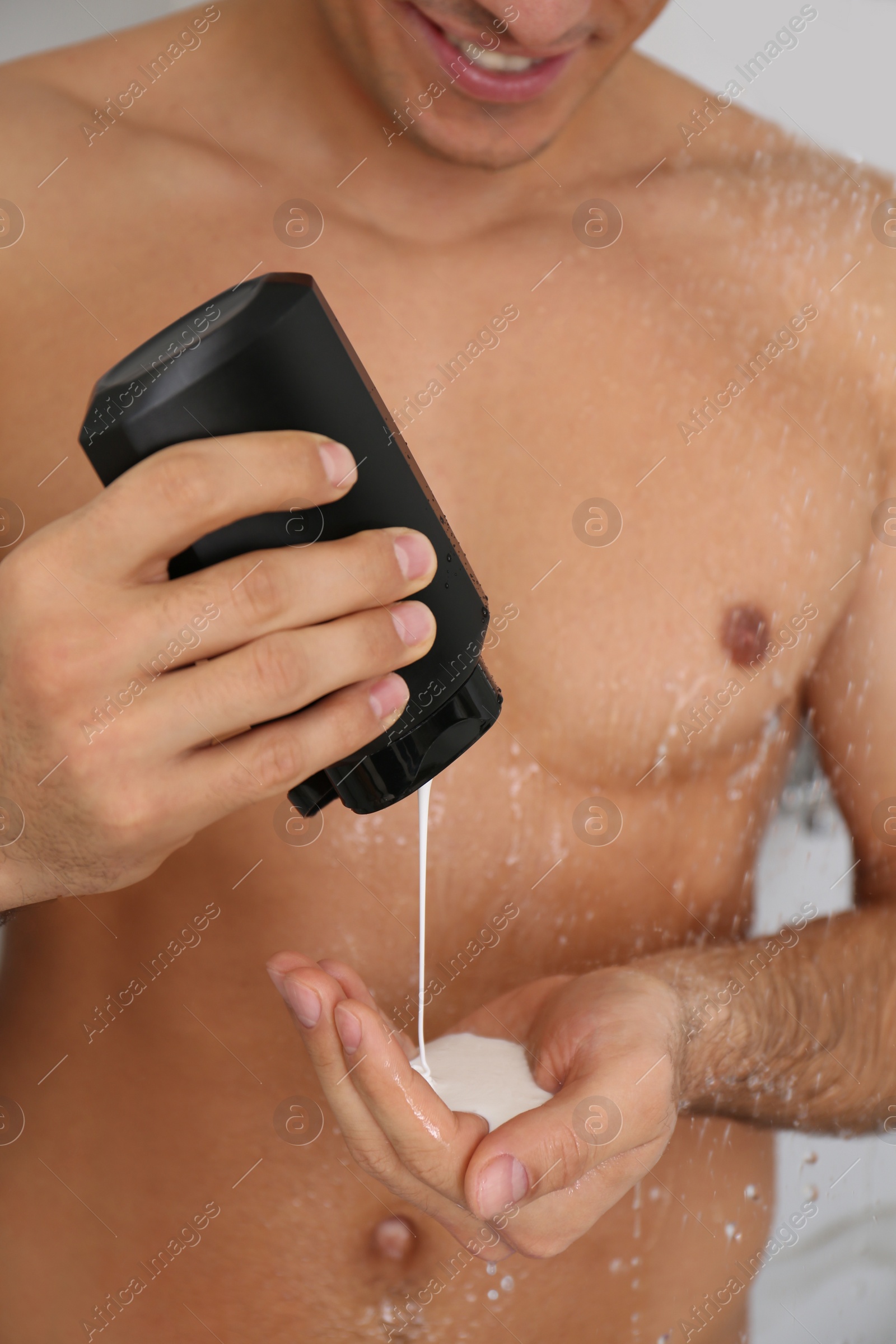 Photo of Man applying gel in shower at home, closeup