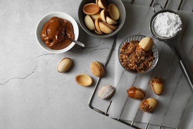 Photo of Delicious walnut shaped cookies with condensed milk on grey table, flat lay