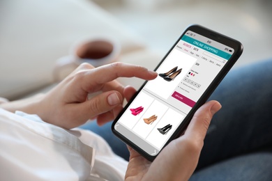 Image of Woman shopping online via smartphone indoors, closeup