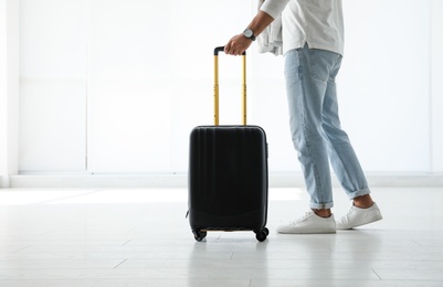 Photo of Man with black travel suitcase in airport. Space for text