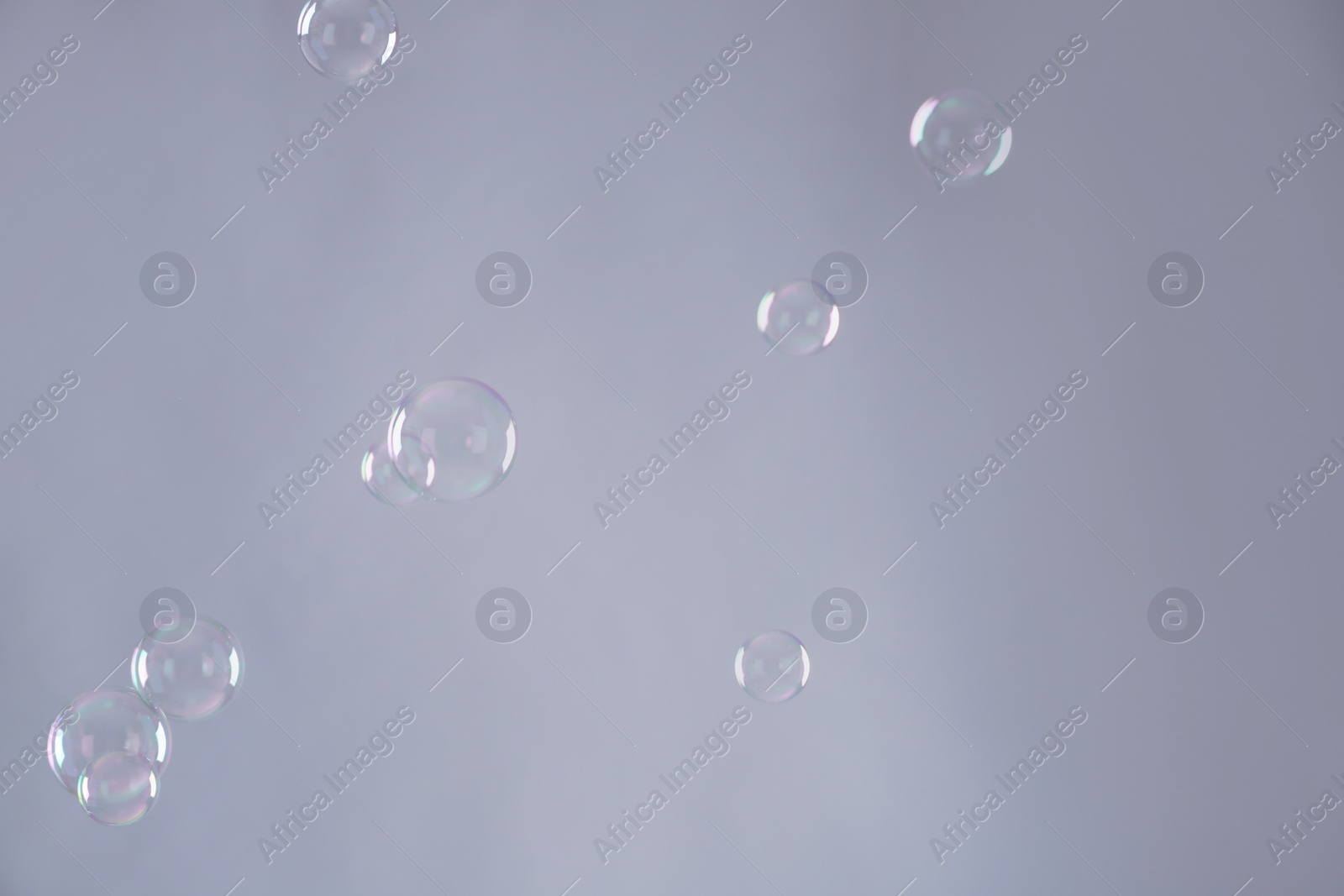 Photo of Beautiful translucent soap bubbles on grey background