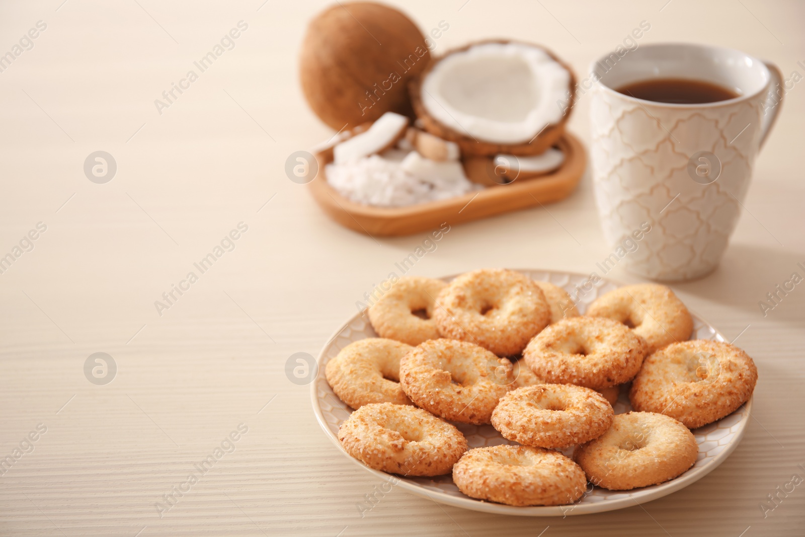 Photo of Plate with cookies and cup of tea on wooden background