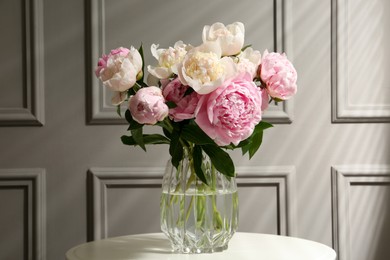 Photo of Bouquetbeautiful peonies in glass vase on white table