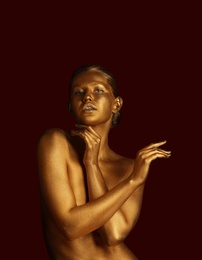 Photo of Portrait of beautiful lady with gold paint on skin against color background