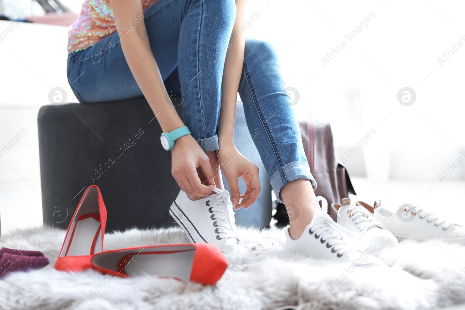 Photo of Young woman trying on shoes in store